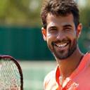Foto de Javier P., tenista amateur, sonriendo en la cancha.
